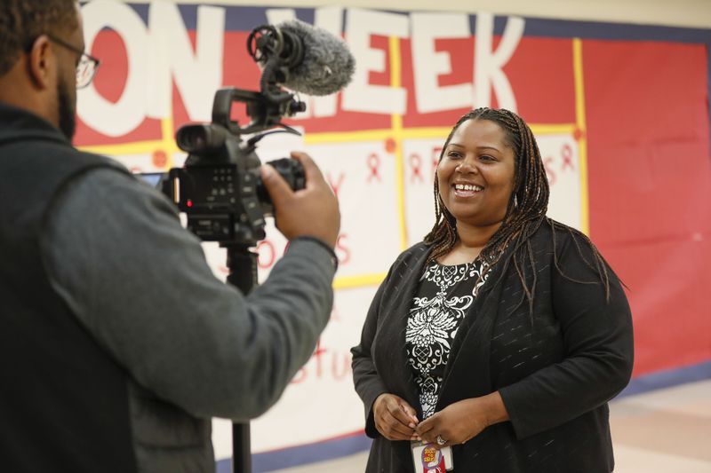 Harper-Archer Elementary School Principal Dione Simon Taylor makes a quick video for the district's awards ceremony, one of many tasks she checks off during a busy October school day.  Bob Andres / robert.andres@ajc.com