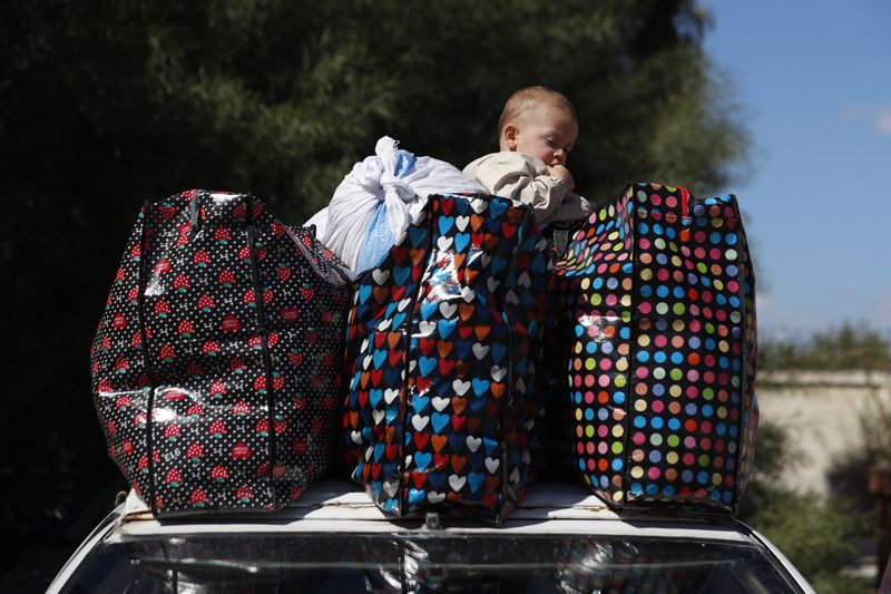 A Syrian kid fleeing the war in Lebanon with his family, sits on the top of car between belongings, at the Syrian-Lebanese border crossing in Jousieh, Syria, Tuesday, Oct. 2, 2024. (AP Photo/Omar Sanadiki)