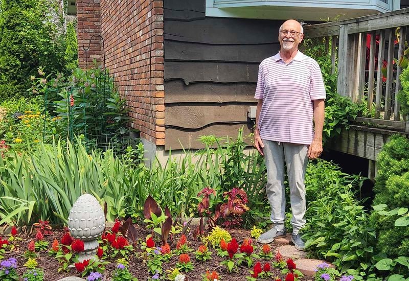 Jeff Kellert stands in his garden at his home in Albany, N.Y. on June 20, 2024. Kellert began volunteering as a tutor and helped with monthly dinners at his synagogue. The experience keeps him active, but just as important, he said, it has led to new friendships and a sense of purpose he never expected in retirement. (Robert Piechota via AP)