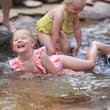 Four-year-old Nelle Boyd, center facing, plays in the water with her sister Scarlett, 2, of Norcross, at the water feature near the playground at Brook Run Park, Thursday, June 13, 2024, in Dunwoody, Ga. The two girls were there with their mother Julianne Boyd. The weather is project to be in the high 90s over the weekend. (Jason Getz / AJC)
