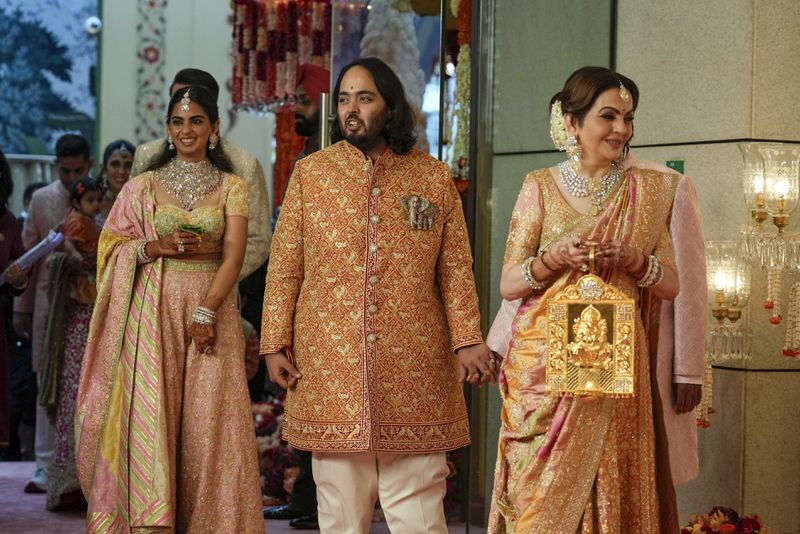 Billionaire Mukesh Ambani's son Anant Ambani, center, stands with mother Neeta Ambani, right, and sister Isha Piramal Ambani at his and Radhika Merchant's wedding at Jio World Convention Centre in Mumbai, India, Friday, July 12, 2024. (AP Photo /Rajanish Kakade)