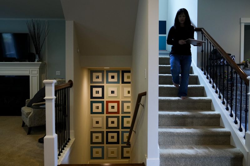 Ellen Lo Hoffman, the co-founder of Soul Reparations, a nonprofit providing free spiritual support to women, walks down the stairs at her home Wednesday, Aug. 21, 2024, in Bothell, Wash. (AP Photo/Lindsey Wasson)