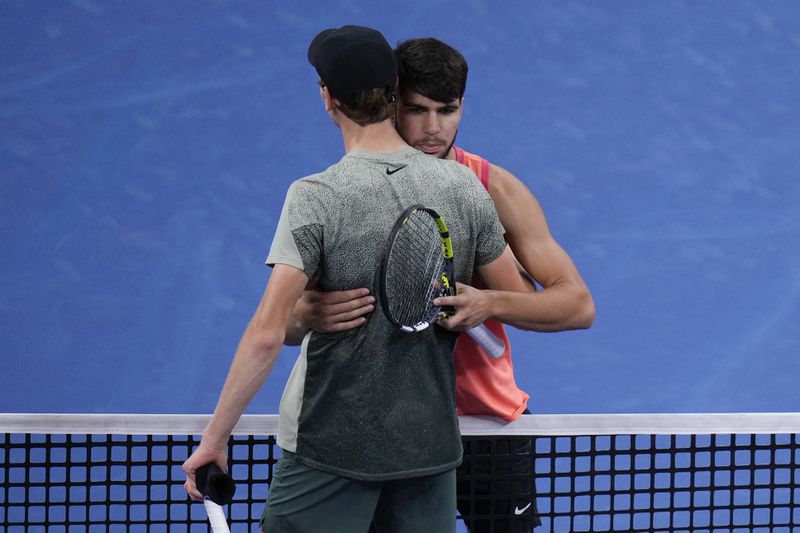 Carlos Alcaraz, right, of Spain approaches the net after winning against Jannik Sinner of Italy during their men's singles finals match of the China Open tennis tournament, at the National Tennis Center in Beijing, Wednesday, Oct. 2, 2024. (AP Photo/Andy Wong)