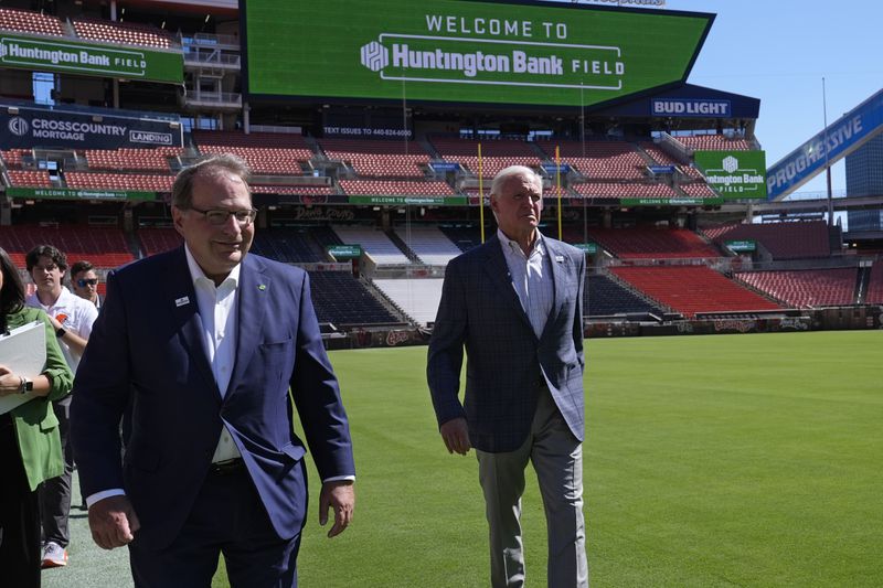 Huntington Banks' Steve Steinour, left, Huntington Bank chairman, president and chief executive officer, and Cleveland Browns owner Jimmy Haslam, right, walk on the field following an NFL football news conference announcing Cleveland Browns Stadium will now be called Huntington Bank Field, Tuesday, Sept. 3, 2024, in Cleveland. (AP Photo/Sue Ogrocki)