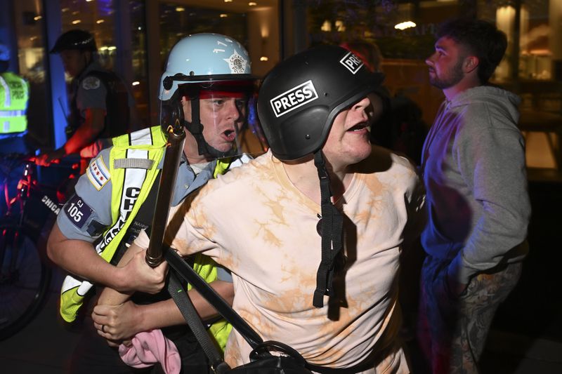 A demonstrators is taken into custody by police police near the Israeli Consulate during the Democratic National Convention Tuesday, Aug. 20, 2024, in Chicago. (AP Photo/Noah Berger)