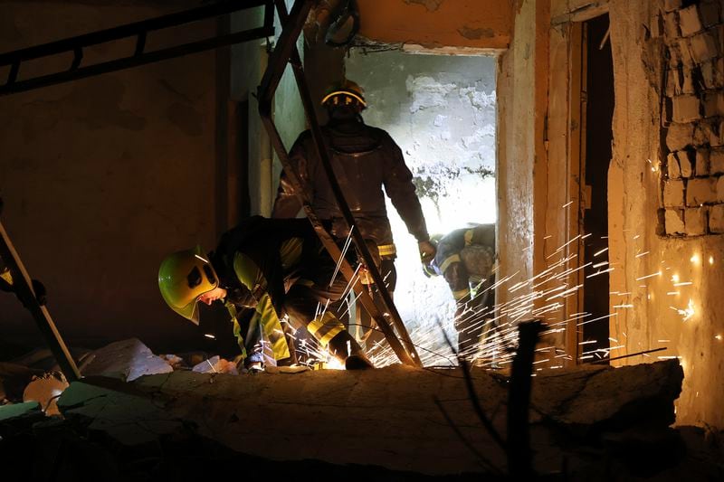 Emergency services workers move rubble after a Russian strike on a residential building in Kharkiv, Ukraine early Sunday Sept. 22, 2024. (Kharkiv Regional Military Administration via AP)