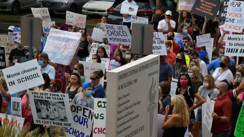 Parents, students and supporters rally against Gwinnett County Public School's decision to make all fall instruction online-only outside Gwinnett Schools Instructional Support Center building in Suwanee on Friday, July 24. (Hyosub Shin / Hyosub.Shin@ajc.com)