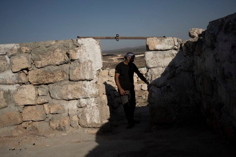 Hassan Battat stands in what remains of his home in the West Bank village of Khirbet Zanuta, Thursday, Aug. 29, 2024. Ten months after settlers threatened to kill them if they didn't leave their village, some Palestinian residents are finally home, under a rare court order. (AP Photo/Maya Alleruzzo)