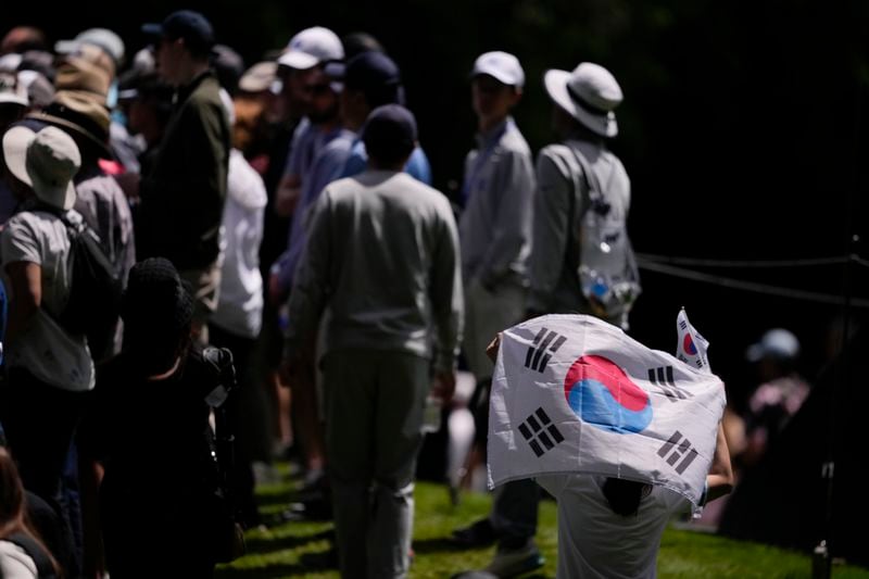 A spectator holds South Korea flags during the final round of the Women's PGA Championship golf tournament at Sahalee Country Club, Sunday, June 23, 2024, in Sammamish, Wash. (AP Photo/Lindsey Wasson)