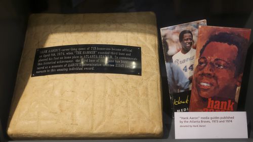 This is third base that Hank Aaron stepped on after he hit home run No. 715 on April 8, 1974, at Atlanta Stadium, shown in the exhibit, The Hank Aaron: Chasing The Dream, at the National Baseball Hall of Fame, Thursday, May 23, 2024, in Cooperstown, NY. Also pictured are media guides from the Atlanta Braves from 1973 and 1974. This is one of only two exhibits in the museum dedicated to telling the story of a single player.(Jason Getz / AJC)
