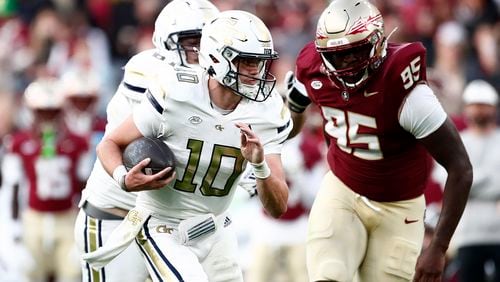 Georgia's Haynes King, left, and Florida's Daniel Lyons challenge for the ball during the NCAA college football game between Georgia Tech and Florida State at the Aviva stadium in Dublin, Saturday, Aug. 24, 2024. (AP Photo/Peter Morrison)