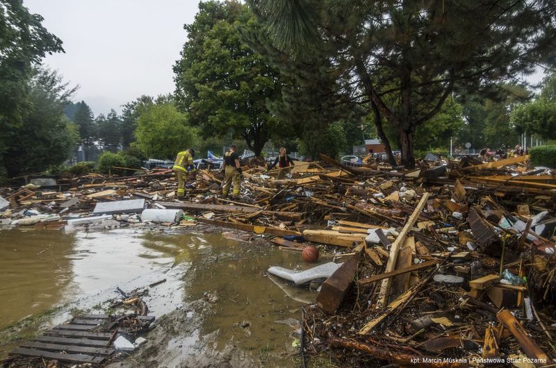 This handout photo provided by the Polish fire department, shows firefighters removing piles of debris dumped in the streets by high flood wave that is passing through southwestern Poland, in Glucholazy, Poland, on Tuesday, Sept. 17, 2024. ( Marcin Muskala/KG PSP via AP)