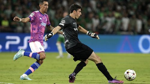 Maccabi's goalkeeper Josh Cohen kicks the ball as Juventus' Angel Di Maria tries to stop him during the group H Champions League soccer match between Maccabi Haifa and Juventus at Sammy Ofer stadium, in Haifa, Israel, Tuesday, Oct. 11, 2022. (AP Photo/Ariel Schalit)