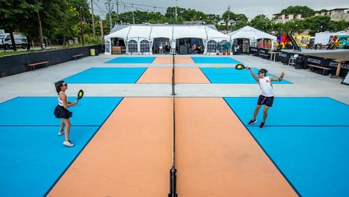 Hannah Foster, left, and Sean Peacock, right, play a quick game of pickleball at Pullman Yards before a storm rolls in. Played on courts significantly smaller than tennis, pickleball has been billed as America’s fastest-growing sport. (Jenni Girtman for The Atlanta Journal-Constitution)