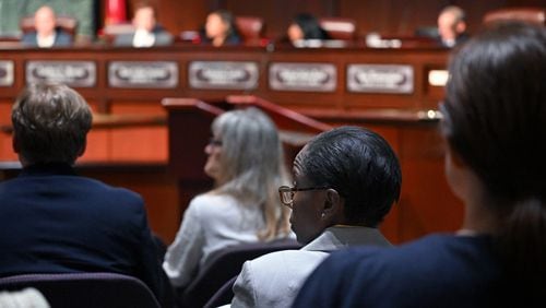 Inspector General Shannon Manigault (center) listens as task force members (background) confer during the first meeting of a task force established to review the inspector general's authority at Atlanta City Hall, Tuesday, September 24, 2024, in Atlanta. The task force established to review the procedures of the Office of the Inspector General and Ethics Office met for the first time Tuesday. (Hyosub Shin / AJC)