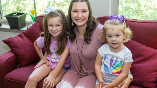 Emberly Burns, 7, (from left) her mother Amber and sister Amelia,2, sit together on the couch in their apartment in Atlanta. Burns, a Caringworks client, is a single mother who has faced many trials including drug addiction, an abusive relationship and homelessness. PHIL SKINNER FOR THE ATLANTA JOURNAL-CONSTITUTION