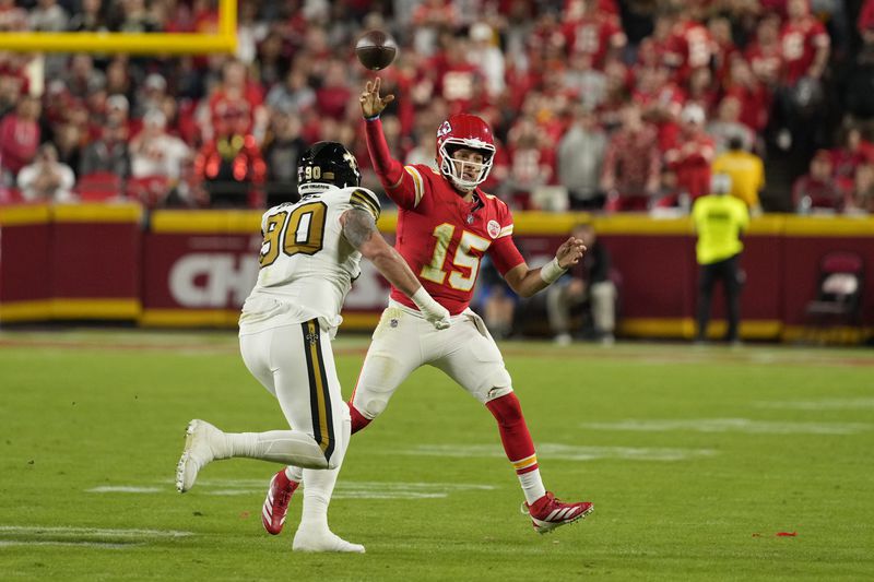 Kansas City Chiefs quarterback Patrick Mahomes (15) throws over New Orleans Saints defensive tackle Bryan Bresee (90) during the first half of an NFL football game Monday, Oct. 7, 2024, in Kansas City, Mo. (AP Photo/Charlie Riedel)