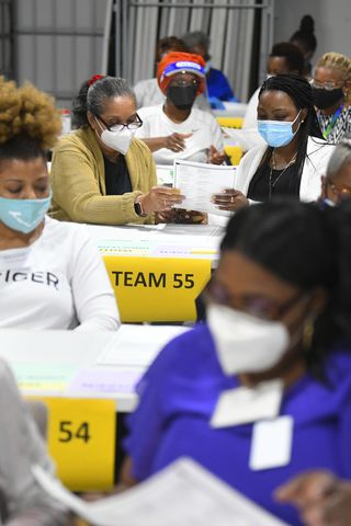Election workers work in teams with a partner as votes for President are recounted at the Gwinnett County elections office on Friday, Nov.13, 2020 in Lawrenceville. (JOHN AMIS FOR THE ATLANTA JOURNAL-CONSTITUTION)
