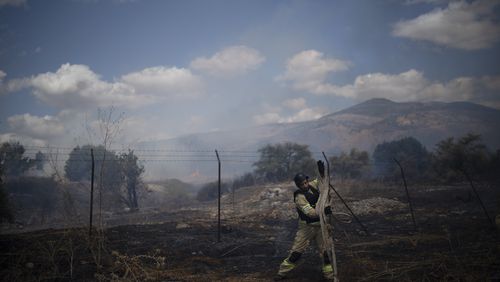 An Israeli firefighter works to extinguish a fire burning in an area, following an attack from Lebanon, near the Kibbutz Snir, northern Israel, Monday, Sept. 16, 2024. (AP Photo/Leo Correa)