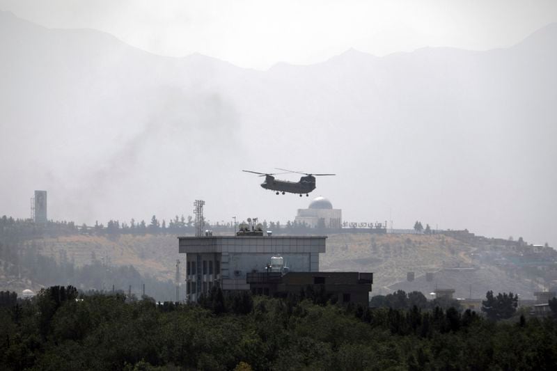 FILE - A U.S. Chinook helicopter flies over the U.S. embassy in Kabul, Afghanistan, on Sunday, Aug. 15, 2021, as the capital was captured by Taliban forces. (AP Photo/Rahmat Gul, File)