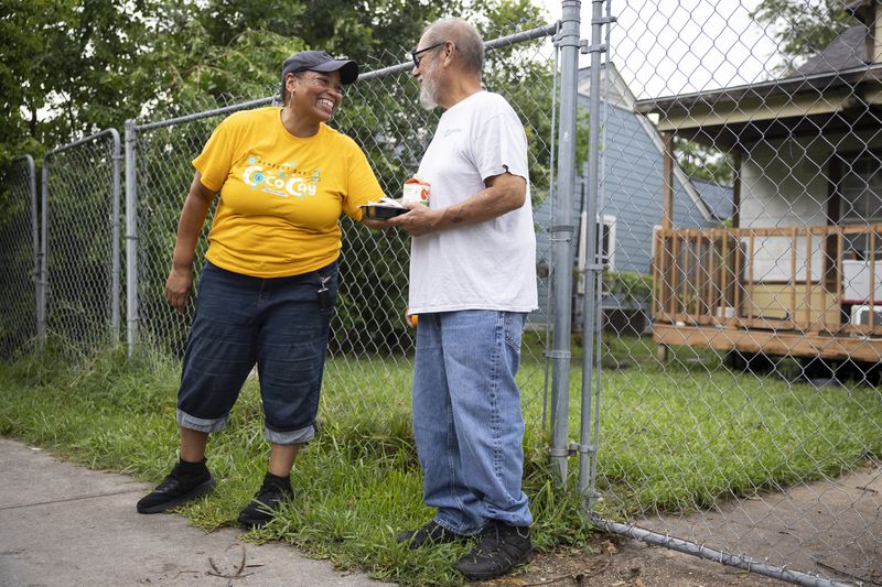 Meals on Wheels delivery driver Debbie Hardison smiles as she delivers a hot meal to Jorge Aranzeta, Friday, July 12, 2024, in Houston. Aranzeta was one of the 2.7 million Houstonians who lost power after Hurricane Beryl's winds ripped through Houston early Monday morning. (AP Photo/Annie Mulligan)