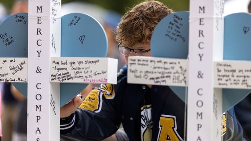 Mourners sign crosses at a vigil at Jug Tavern Park in Winder on Friday, Sept. 6, 2024. A 14-year-old Apalachee High School student is accused of shooting and killing two fellow students and two teachers and injuring nine others at the Barrow County high school on Wednesday. (Arvin Temkar / AJC)