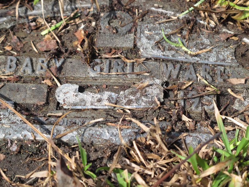 A crumbling tin plaque marks the grave of an infant buried during the 1950s in the “Babyland” section of Onslow Memorial Park in Jacksonville, N.C., near Camp Lejeune. AP PHOTO / ALLEN BREED