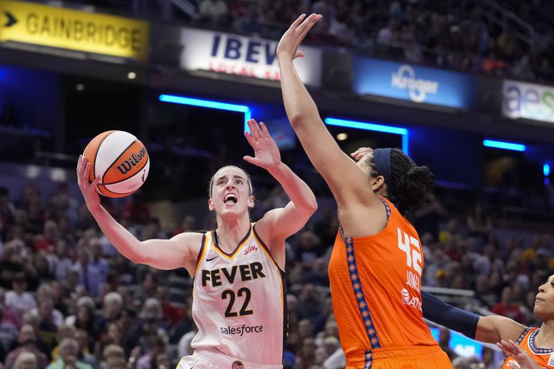 Indiana Fever guard Caitlin Clark (22) shot over Connecticut Sun forward Brionna Jones (42) in the second half of a WNBA basketball game in Indianapolis, Wednesday, Aug. 28, 2024. (AP Photo/Michael Conroy)