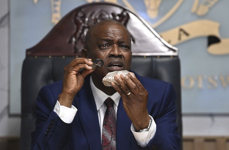 Botswana's President Mokgweetsi Masisi holds the 2,492-carat diamond that was unearthed at one of its mines and will be put on show, Thursday, Aug. 22, 2024, in Gaborone. (AP Photo)