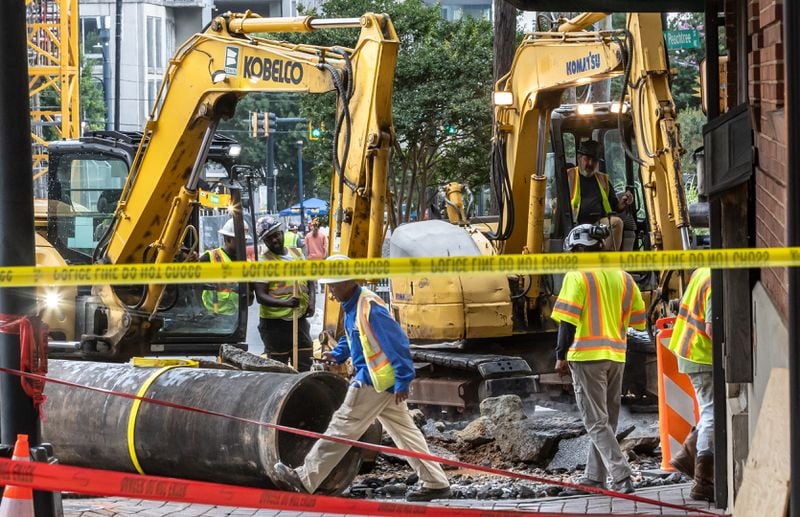 Crews worked on a broken main on West Peachtree Street at 11th Street in Midtown, with nearby residents warned of impacts to their water service as the crisis reached its fourth day Monday, June 3, 2024. Water had been gushing out of the broken main until Monday morning, when workers were seen pumping out water. (John Spink/AJC)