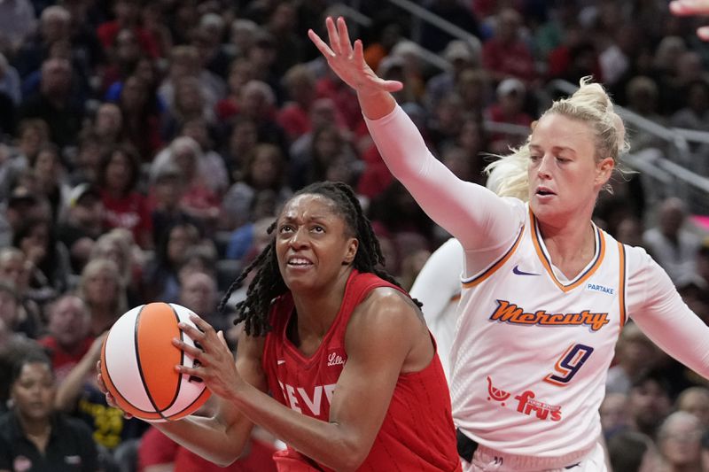 Indiana Fever's Kelsey Mitchell, left, goes to the basket against Phoenix Mercury's Sophie Cunningham (9) during the second half of a WNBA basketball game, Friday, Aug. 16, 2024, in Indianapolis. (AP Photo/Darron Cummings)