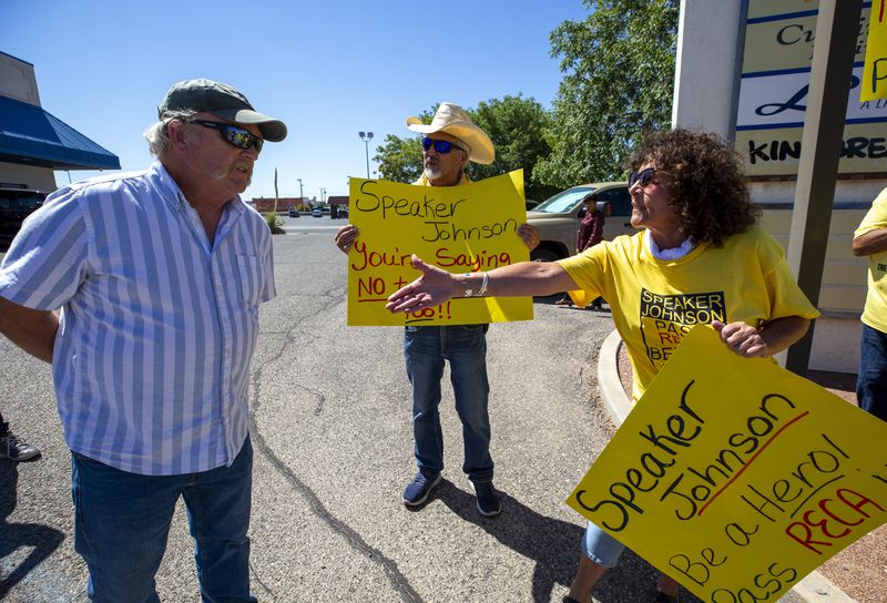 Tina Cordova, right, an activist with the Tularosa Basin Downwinders Consortium, offers a handshake to an attendee of a campaign event with House Speaker Mike Johnson and Republican U.S. House candidate Yvette Herrell of New Mexico, during a demonstration in Las Cruces, N.M., Wednesday, Aug. 21, 2024. The Consortium is asking Speaker Johnson to pass a Senate bill to expand the Radiation Exposure Compensation Act to include New Mexico Downwinders and post 1971 Uranium Miners. (AP Photo/Andres Leighton)