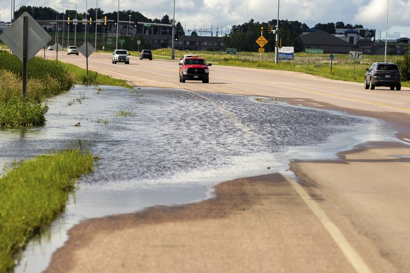 A South Dakota Department of Transportation truck blocks traffic from floodwaters caused by heavy rainfall, Saturday, June 22, 2024, in Sioux Falls, S.D. (AP Photo/Josh Jurgens)