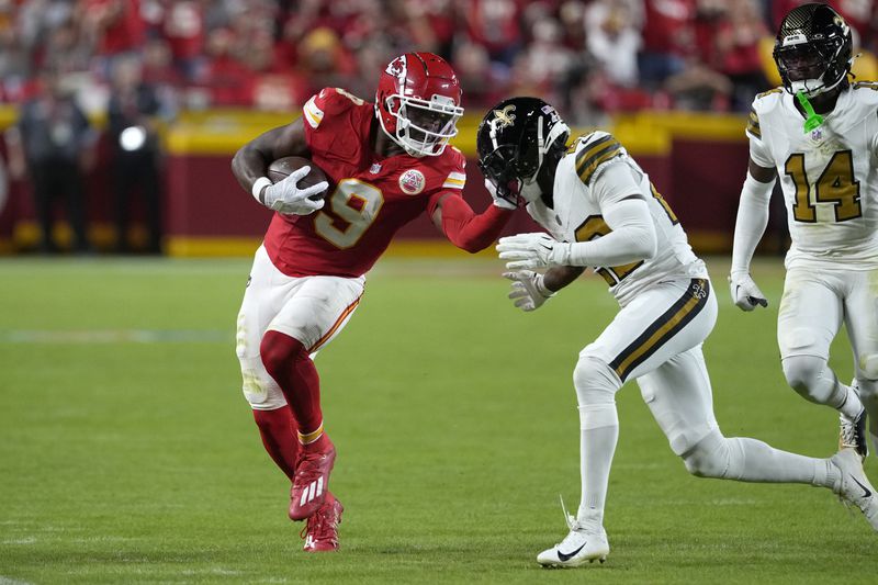 Kansas City Chiefs wide receiver JuJu Smith-Schuster (9) is forced out of bounds by New Orleans Saints cornerback Paulson Adebo after catching a pass during the first half of an NFL football game Monday, Oct. 7, 2024, in Kansas City, Mo. (AP Photo/Ed Zurga)