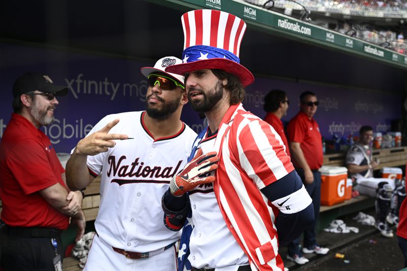 Washington Nationals' Jesse Winker, right, poses with Luis Garcia Jr., left, as he celebrates his home run during the eighth inning of a baseball game against the New York Mets, Thursday, July 4, 2024, in Washington. The Nationals won 1-0. (AP Photo/Nick Wass)