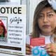 Leslie Palomino, holding “a know your rights" card, poses for a portrait at her home in Gwinnett County on Friday, July 5, 2024. Her door has a sign that states federal agents cannot enter without a warrant signed by a judge. (Arvin Temkar / AJC)