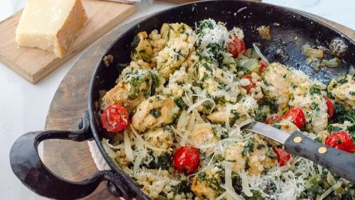 Skillet Spinach Chicken served with pearl couscous and grape tomatoes, topped with Parmesan cheese.
(Virginia Willis for The Atlanta Journal-Constitution)