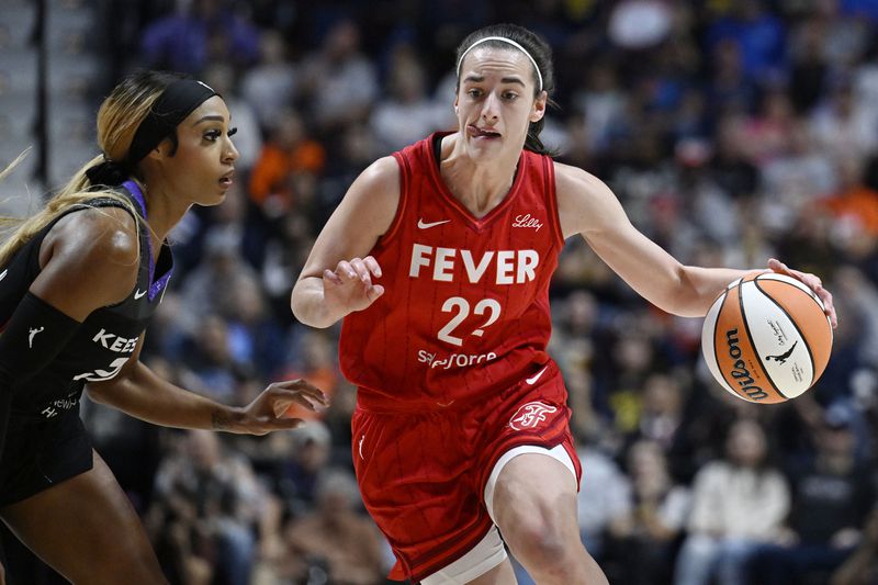 Indiana Fever guard Caitlin Clark (22) drives to the basket as Connecticut Sun guard DiJonai Carrington defends during a first-round WNBA basketball playoff game, Wednesday, Sept. 25, 2024, in Uncasville, Conn. (AP Photo/Jessica Hill)