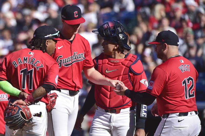 Cleveland Guardians relief pitcher Tim Herrin, second from left, hands the ball to manager Stephen Vogt (12) as he is taken out of the game in the eighth inning during Game 1 of baseball's AL Division Series against the Detroit Tigers, Saturday, Oct. 5, 2024, in Cleveland. (AP Photo/Phil Long)