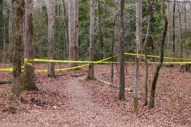 Police tape ropes off the crime scene on a trail behind Lake Herrick in Athens at the University of Georgia on Friday, Feb. 23, 2024. A female nursing student was found dead nearby the day before. (Jason Getz / jason.getz@ajc.com)