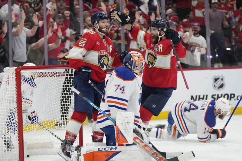 Florida Panthers defenseman Aaron Ekblad (5) congratulates left wing Matthew Tkachuk (19) after Tkachuk scored a goal against Edmonton Oilers goaltender Stuart Skinner (74) during the second period of Game 5 of the NHL hockey Stanley Cup Finals, Tuesday, June 18, 2024, in Sunrise, Fla. (AP Photo/Wilfredo Lee)