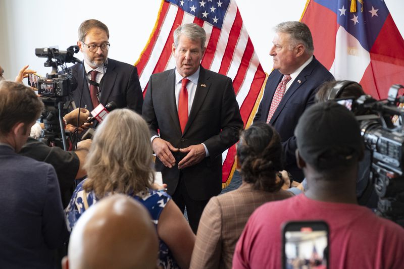 Gov. Brian Kemp flanked by Department of Community Health Commissioner Russel Carlson (left) and Insurance Commissioner John King.