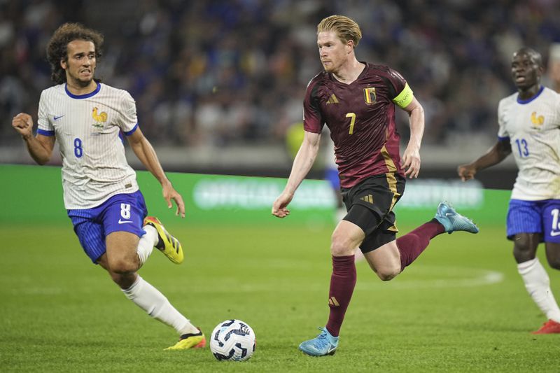 France's Matteo Guendouzi, left, runs to stop Belgium's Kevin De Bruyne during the UEFA Nations League soccer match between France and Belgium at the Groupama stadium in Decines, outside Lyon, France, Monday, Sept. 9, 2024. (AP Photo/Laurent Cipriani)