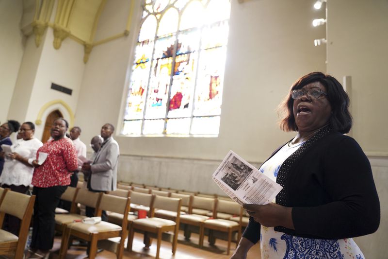 Louisette Saintima, right, and other congregants sing during Mass at St Raphael Catholic church in Springfield, Ohio, Sunday, Sept. 15, 2024. (AP Photo/Jessie Wardarski)