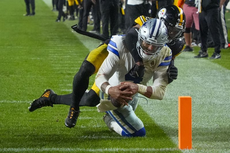 Dallas Cowboys quarterback Dak Prescott, front, is stopped short of the goal line by Pittsburgh Steelers safety Minkah Fitzpatrick during the second half of an NFL football game, early Monday, Oct. 7, 2024, in Pittsburgh. The Cowboys won 20-17. (AP Photo/Gene J. Puskar)