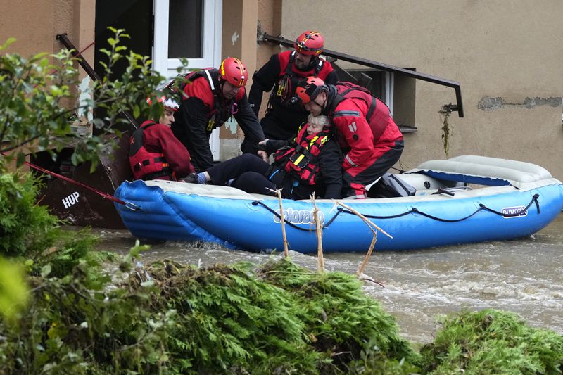 A resident is evacuated from his flooded house in Jesenik, Czech Republic, Sunday, Sept. 15, 2024. (AP Photo/Petr David Josek)