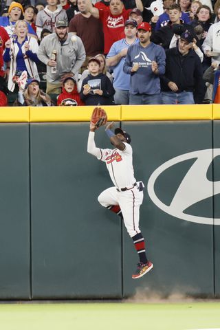 Atlanta Braves center fielder Michael Harris II (23) jumps against the fence to catch the ball during the second inning at Truist Park on Saturday, Oct. 1, 2022. Miguel Martinez / miguel.martinezjimenez@ajc.com 