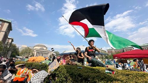 FILE - A demonstrator waves a flag on the Columbia University campus at a pro-Palestinian protest encampment, in New York, April 29, 2024. (AP Photo/Ted Shaffrey, File)