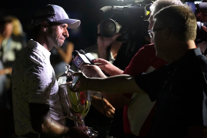 Aaron Rai, of England, left, talks to the media after winning the Wyndham Championship golf tournament in Greensboro, N.C., Sunday, Aug. 11, 2024. (AP Photo/Chuck Burton)