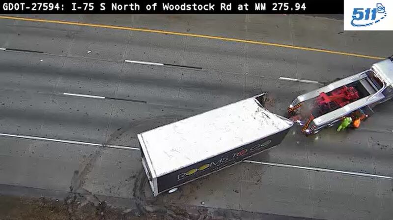 Workers try to move a crashed tractor-trailer on I-75 South near Acworth on Wednesday morning.